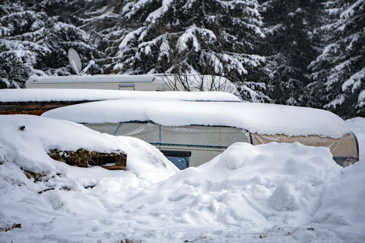 Poulailler familial en hiver avec litière épaisse, abreuvoir protégé et aérations hautes visibles.